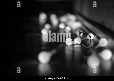 Schwarze und weiße Stimmung und Ton in der Nähe zu sehen, der dekorativen Kabel led Kleine warm-weißes Licht Lampen auf dem Boden lag an der Ecke Dunkel und Dunkel. Stockfoto