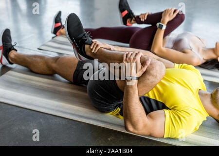 Blick auf Sportler und Sportlerin, die sich auf Fitness Matten im Sportzentrum 7/8 Stockfoto