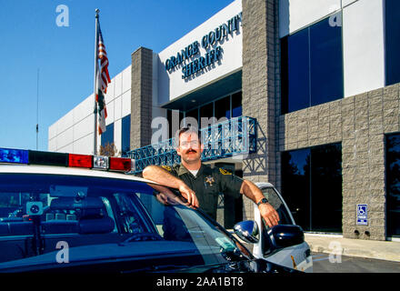 Eine Orange County, CA, Sheriff's Deputy stellt mit seinem streifenwagen außerhalb einer Sheriff Department Unterstation in Aliso Viejo, CA. Stockfoto