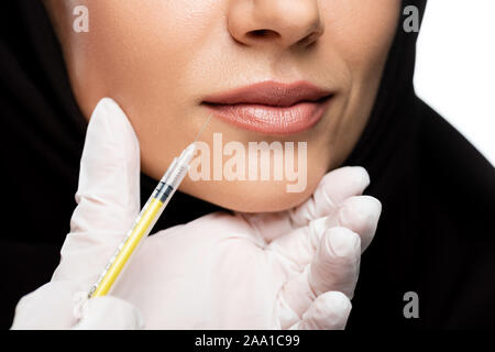 7/8-Ansicht von jungen muslimischen Frau im Hijab in Schönheit Injektion auf Weiß, Lippenvergrößerung Konzept isoliert Stockfoto