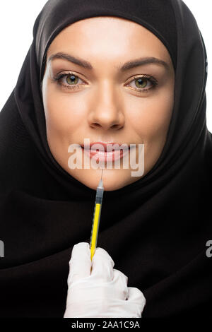 Junge muslimische Frau mit Kopftuch in Schönheit Injektion auf Weiß, Lippenvergrößerung Konzept isoliert Stockfoto