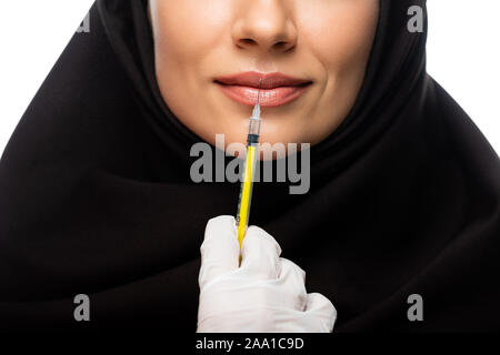 Teilweise mit Blick auf die junge muslimische Frau mit Kopftuch in Schönheit Injektion auf Weiß, Lippenvergrößerung Konzept isoliert Stockfoto