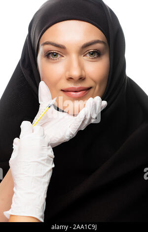 Junge muslimische Frau mit Kopftuch in Schönheit Injektion auf Weiß, Lippenvergrößerung Konzept isoliert Stockfoto