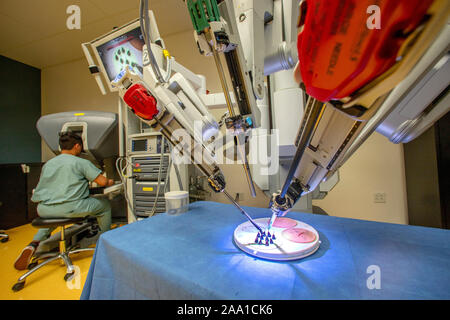 Ein Da Vinci Operationsroboter Praktiken komplexe Operation mit einem minimal-invasiven Ansatz durch ein Chirurg aus einer Konsole in einer Demonstration in einem Orange, CA, Krankenhaus gesteuert. Stockfoto