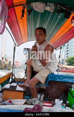 Mann die Erprobung einer Long-Tail Boot in Bangkok, Thailand Stockfoto