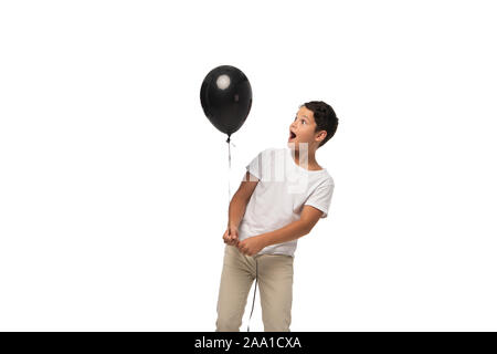 Überrascht junge Blick auf schwarze Ballon beim Stehen auf weißen isoliert Stockfoto