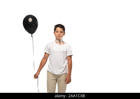 Verärgert boy Holding schwarze Ballon beim Stehen auf weißen isoliert Stockfoto