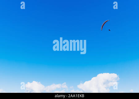 Gleitschirm über die Berge an einem hellen Sommertag zu fliegen. Paragliding Sport Konzept. Kopieren Sie Platz. Stockfoto