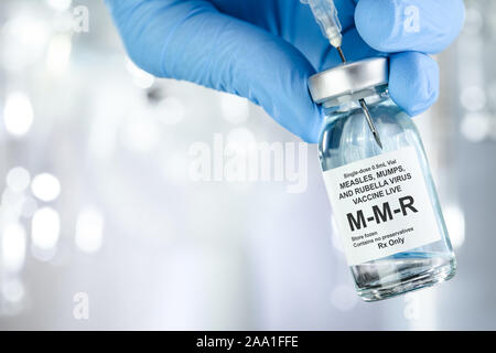 Healthcare Konzept mit einer Hand in Blau medizinische Handschuhe holding MMR, Masern, Mumps und Röteln Impfstoff Durchstechflasche Stockfoto