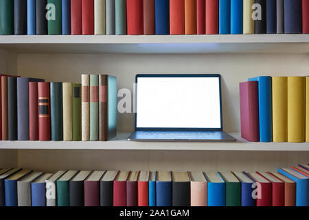 Bücherregal mit Laptop Stockfoto