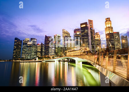 Atemberaubende Aussicht auf die Marina Bay Skyline mit schönen beleuchteten Wolkenkratzer bei einem atemberaubenden Sonnenuntergang in Singapur. Stockfoto