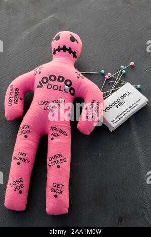 Rosa Voodoo Puppe mit einem Bücher von Voodoo Pins und Nadeln Stockfoto