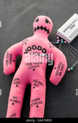 Rosa Voodoo Puppe mit einem Bücher von Voodoo Pins und Nadeln Stockfoto