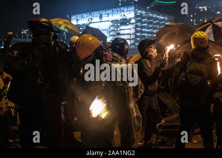 Hongkong, China. 17. Nov, 2019. Die Demonstranten werfen Benzinbomben in Richtung der Bereitschaftspolizei bei den Auseinandersetzungen. Hong Kong Polizei Polytechnische Universität Surround während der heftigen Auseinandersetzungen. Auseinandersetzungen zwischen Demonstranten und Polizisten weiter um die Polytechnische Universität von den ganzen Tag auszubrechen. Polizei verwendet die Wasserwerfer, Tränengas und Gummigeschossen, während Demonstranten mit Benzinbomben und Ziegeln reagiert. Die meisten der Kämpfe konzentriert an der Kreuzung vor dem Haupteingang der Schule. Credit: SOPA Images Limited/Alamy leben Nachrichten Stockfoto