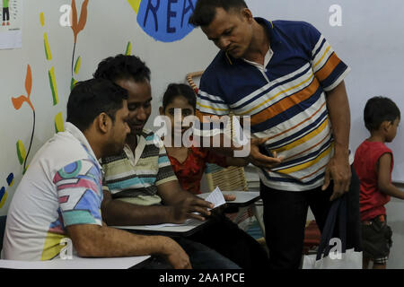 Kuala Lumpur, Selangor, Malaysia. 11 Nov, 2019. Ein freiwilliger Lehrer hilft ein älterer Student an der Akademie. Rohingya English Academy ist ein Learning Center, die freie Bildung auf die Rohingya-flüchtlinge sowohl für Kinder als auch für Erwachsene bietet, wurde es von Saif Ullah ein rohingya Bürger leben in Malaysia und auch ein englischer Tutor an der Akademie Wer erhält keine Unterstützung von der Regierung gegründet. Malaysia hat mehr als 177,690 registrierte Flüchtlinge und Asylsuchenden Rohingya Nach UNHCR-Statistik und 45,470 davon sind Kinder unter 18 Jahren. (Bild: © Faris Hadziq/SOPA Bilder v Stockfoto