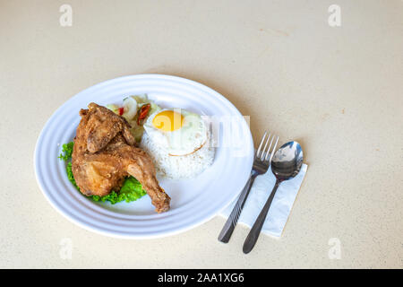 Fried Chicken Sache auf Kopfsalat mit abgeholt Gemüse, Sonnenseite, Spiegelei, und Thai White Jasmin Reis. Essen auf dem Tisch. Stockfoto