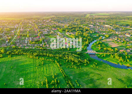 Luftaufnahme Landschaft der Wicklung kleiner Fluss unter der kleinen Stadt, in der grünen Wiese Wiese, Ansicht von oben Stockfoto