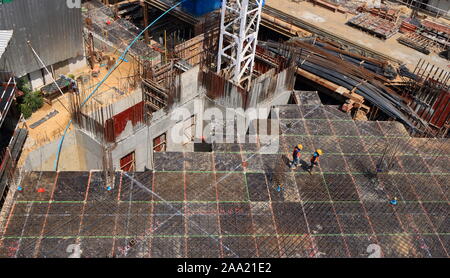 Bangkok, Thailand - 16. November 2019: Zwei Arbeiter gemeinsam zu Fuß auf Betonfertigteilen slap voller Stahl Stäbe an der Baustelle an einem sonnigen Tag Stockfoto