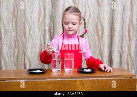Hübsches kleines Mädchen tun physikalische Experimente mit Wasser zu Hause Stockfoto