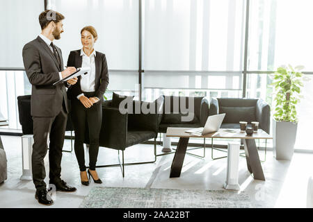 Angestellte von Finanzinstituten oder andere grosse Unternehmen in einigen Unternehmen, stehen und sprechen in den Luxus Büro Stockfoto