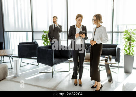 Angestellte von Finanzinstituten oder andere grosse Unternehmen in einigen Unternehmen, stehen und sprechen in den Luxus Büro Stockfoto