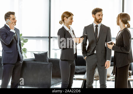 Angestellte von Finanzinstituten oder andere grosse Unternehmen in einigen Unternehmen, stehen und sprechen in den Luxus Büro Stockfoto