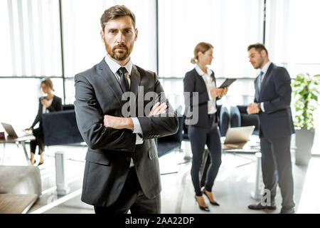 Porträt einer stattlichen weissen Arbeiter vor Business Team im luxuriösen Büro stehend Stockfoto