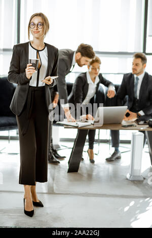 Porträt einer wunderschönen weißen Kragen busines Frau stand vor der Business Team im luxuriösen Büro Stockfoto
