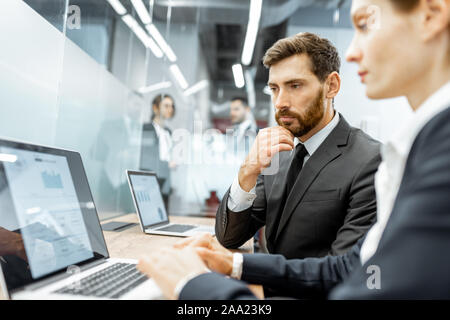Angestellte arbeiten auf dem Laptop am Arbeitsplatz in der Finanzabteilung eines großen Unternehmens Stockfoto