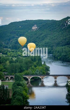 Zwei gelben Heißluft-ballons Fliegen über den Fluss Dordogne mit Chateau castlenaud im Hintergrund Dordogne Frankreich Stockfoto