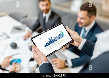 Geschäft Leute während einer Konferenz im Tagungsraum, close-up auf einem digitalen Tablet mit einigen finanziellen Graph Stockfoto
