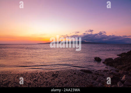 Sonnenaufgang über dem Meer, Watu Dodol Strand - Banyuwangi, Ost Java, Indonesien Stockfoto