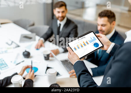 Geschäft Leute während einer Konferenz im Tagungsraum, close-up auf einem digitalen Tablet mit einigen finanziellen Graph Stockfoto