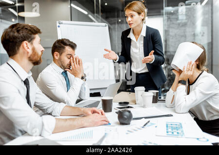 Weibliche Top Manager oder Teamleiter und Mitarbeiter streiten, mit, ihre Arbeit während einer Konferenz im Tagungsraum unzufrieden Stockfoto