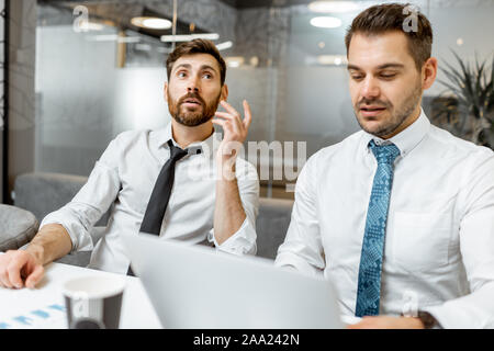 Zwei männliche Mitarbeiter in weißen Hemden und Krawatte in einigen Business Diskussion im Tagungsraum. Stockfoto