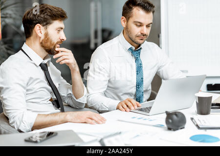 Zwei erschöpft und müde Mitarbeiter hart arbeiten mit Laptop im Büro, Probleme und keine Zeit, ihre Arbeit zu beenden Stockfoto