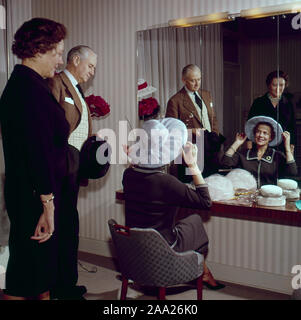 Sie versuchen, Hüte in den 1950er Jahren. Ein Paar sitzt vor einem Spiegel versuchen, Hüte auf. Er ist Humorist Erik Zetterström und sie ist Sickan Carlsson, Schauspielerin. Schweden 1950 Stockfoto