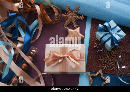 Arbeitsbereich für Geschenkpapier, Gegenwart Boxen verpackt, Papier Farbbänder Kugeln Kugeln Sterne Schere glitzert. Flach. Ansicht von oben. Weihnachten oder Neujahr gi Stockfoto