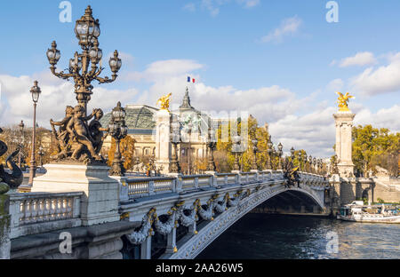 Berühmte Pont Alexandre III Brücke an sonnigen Herbsttag. Hinter ist Dach des Grand Palais mit der Französischen Flagge Verzicht gegen Wolken Stockfoto