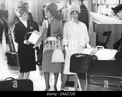 Flugreisen in den 60er Jahren. Zwei junge Frauen, die modische Rechtzeitig 1960 gekleidet s Outfits Kontrolle in Ihrem Gepäck am Flughafen sind. Schweden 1961 Stockfoto