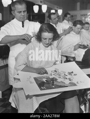 Frau an die Friseure in den 1940er Jahren. Während Sie erhalten einen Haarschnitt und eine neue Frisur Sie layes ein Puzzle. Das Puzzle ist eines Cowboys auf seinem Pferd. 1940 s Stockfoto
