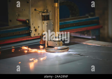 Plasma Schneiden von Metall. Die Maschine schneidet Eisen mit Funken. Die industrielle Herstellung von Produkten aus Eisenblech Stockfoto