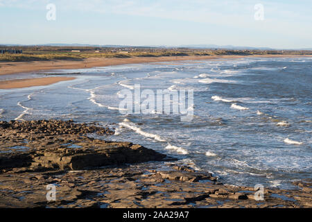 Leistungsschalter nähert sich der Strand zwischen Seaton Sluice und Blyth, mit den Sümpfen Felsen im Vordergrund, Northumberland, England, Großbritannien Stockfoto