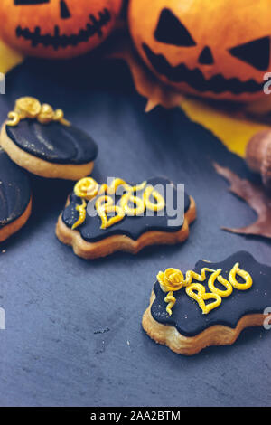 Halloween Lebkuchen Cookies auf dunklem Hintergrund, mit Halloween mini Kürbisse und Dekoration Stockfoto