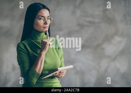 Foto von interessierten erwägend, Frau thoughful Denken auf ihre zukünftigen Pläne holding Notepad isoliert graue Wand Beton Farbe Hintergrund Stockfoto