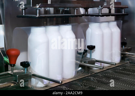 Weißer Kunststoff Flasche Baby Powder Produkte sind Umhüllung in transparente Folie auf der Verpackung der Maschine in der kosmetischen Fabrik. Stockfoto