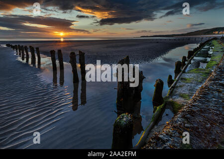 Am frühen Morgen, mit Resten von buhnen, am Strand am Meer Dorf Sandsend, in der Nähe von Whitby, North Yorkshire England Großbritannien Stockfoto