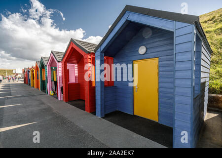 Leitung von farbigen Strand Hütten auf Saltburn Promenade, Saltburn am Meer, North Yorkshire, Großbritannien Stockfoto