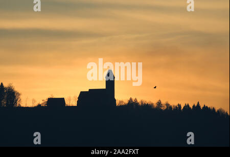 19 November 2019, Baden-Wuerttemberg, Bechingen: Hinter der Wallfahrtskirche St. Johannes Baptist in Uttenweiler-Offingen erhebt sich die Sonne am Morgen. Foto: Thomas Warnack/dpa Stockfoto