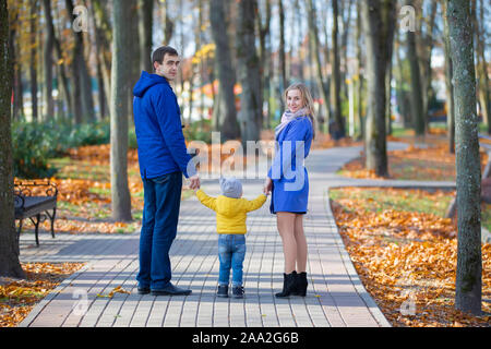 Familie auf einem Spaziergang. Mutter, Vater und Sohn gehen im Herbst Park. Stockfoto